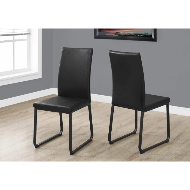 Black faux leather metal dining chairs in modern interior with wood flooring