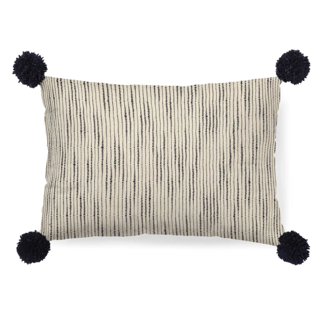 Chic pom pom lumbar accent pillow cover on wooden surface for home decor