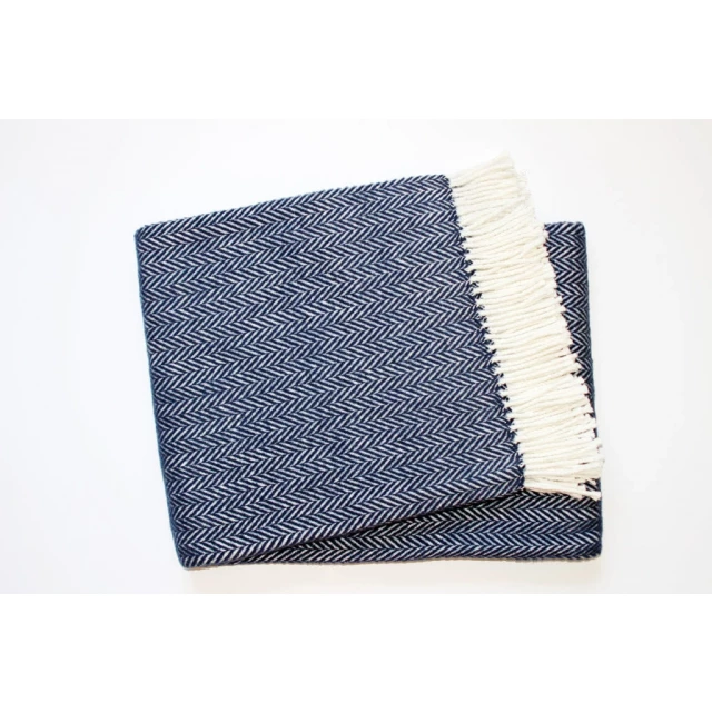 White dreamy soft herringbone throw blanket displayed on denim with a mesh pattern and electric blue accents for online shop