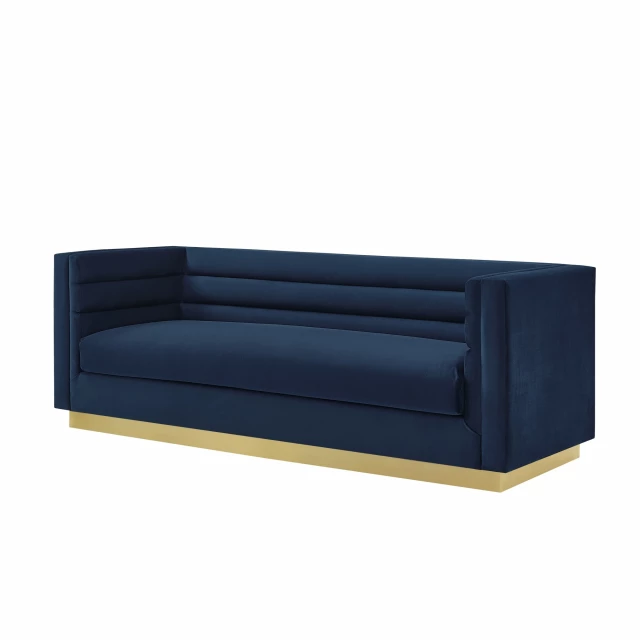Navy blue velvet sofa with comfortable wood base and electric blue accents in a studio setting
