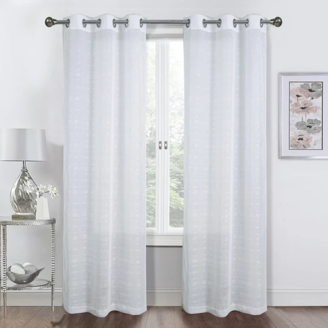 White shimmery window curtain panels in a well-lit interior with wooden flooring