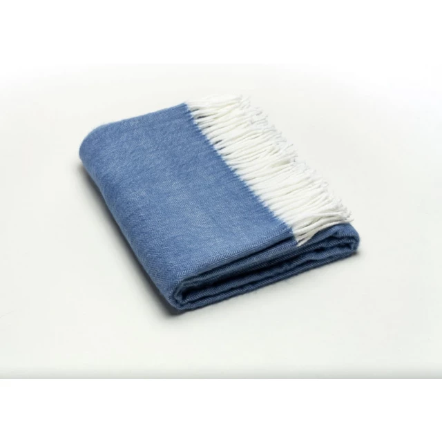 Blue soft acrylic herringbone throw blanket displayed over denim jeans with a rectangular shape and electric blue color