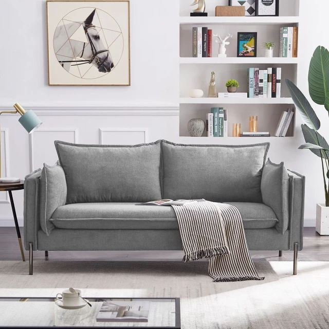 Grey person metal legs sofa in a living room with white rectangle picture frame and shelf