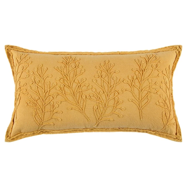 Yellow botanical pattern embroidered lumbar pillow on a couch with gold and wood accents