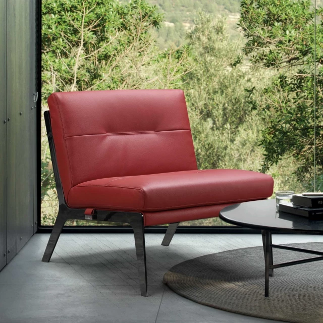Red black genuine leather slipper chair in a cozy outdoor setting with plants and wooden furniture