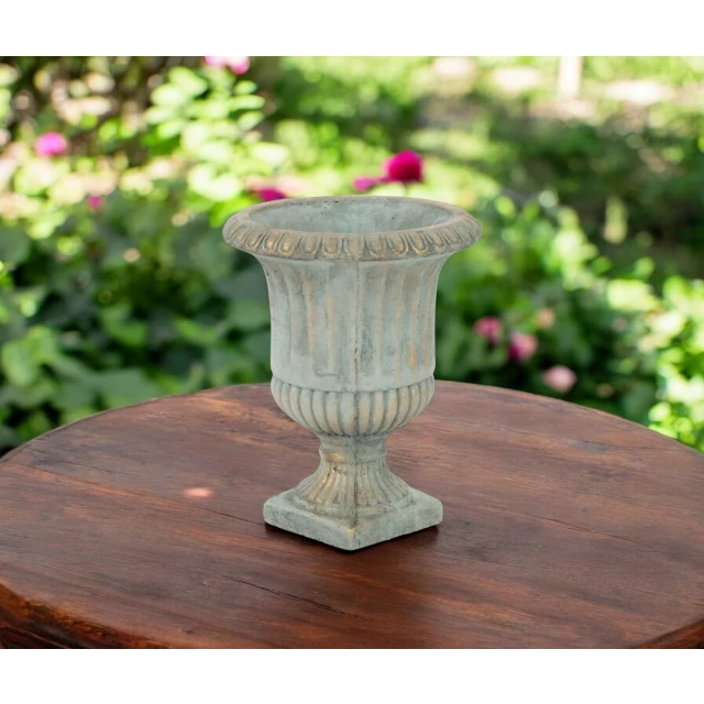 cement indoor outdoor round urn planter with flowers and wooden table