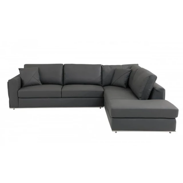Leather reclining L-shaped corner sectional with pillows in a comfortable studio setting