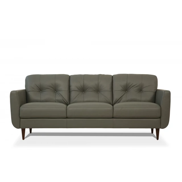Green leather black sofa with wood accents and comfortable studio couch design in furniture showroom