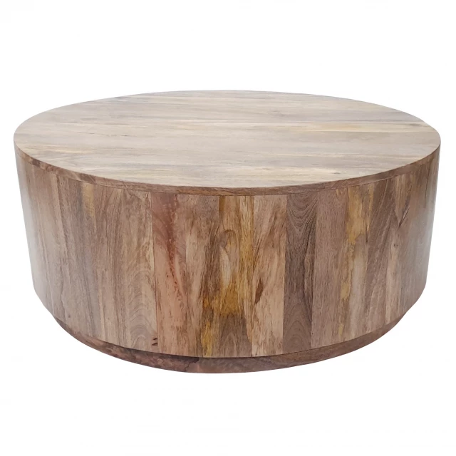 Natural solid wood round coffee table in a room setting with wood stain finish and plant decor