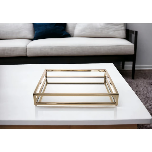 gold square metal serving tray on white couch with wooden table in background