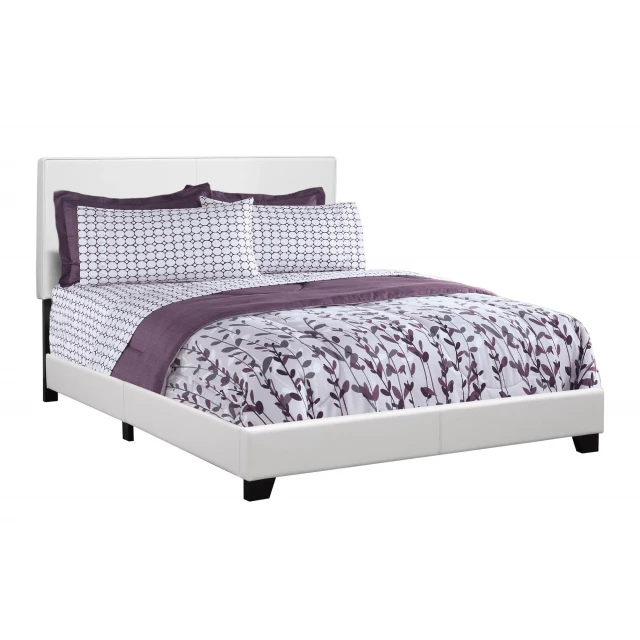 White standard bed with upholstered headboard in a bedroom setting
