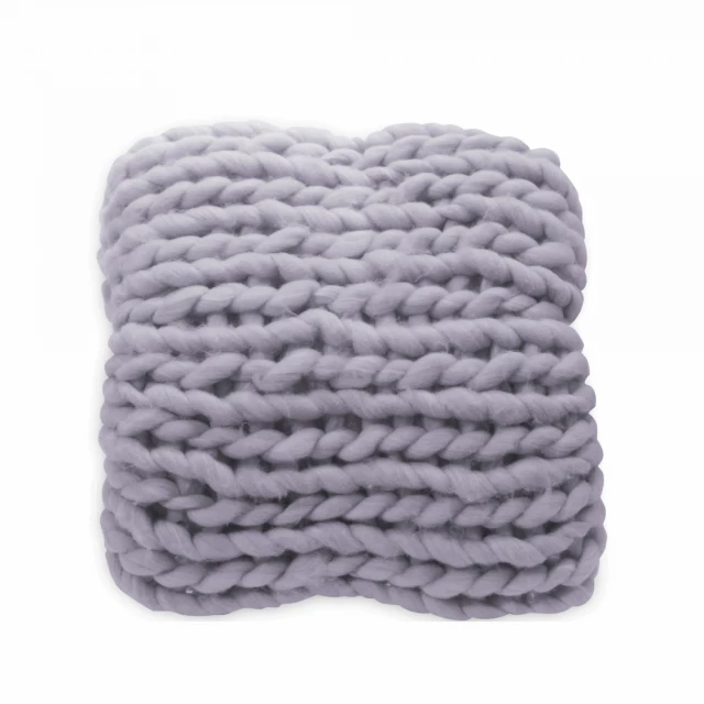 Grey boho chunky knit throw blanket on a woolen hat with plant in background