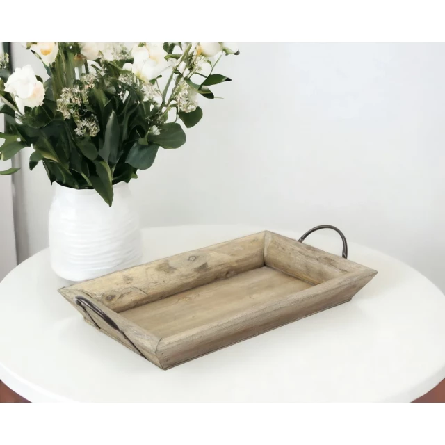 deep wooden tray with metal handles and flowers in a vase