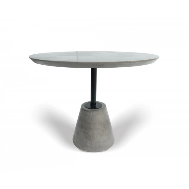 Grey rounded concrete iron dining table with wood accents and circle base in minimalist design