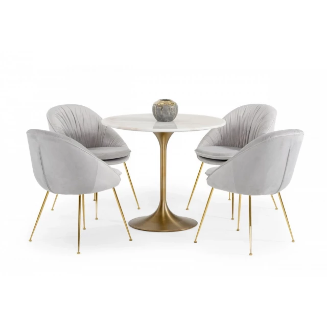 Gold rounded marble metal dining table with chairs and wood accents