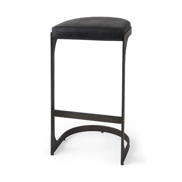 Black iron backless bar chair with wood accents and home accessories in a still life outdoor setting
