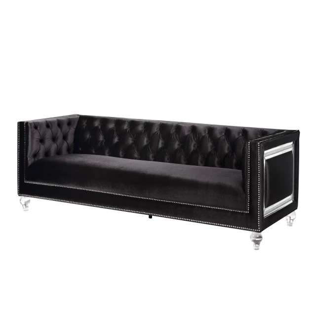 Black velvet sofa with clear toss pillows and metal accents
