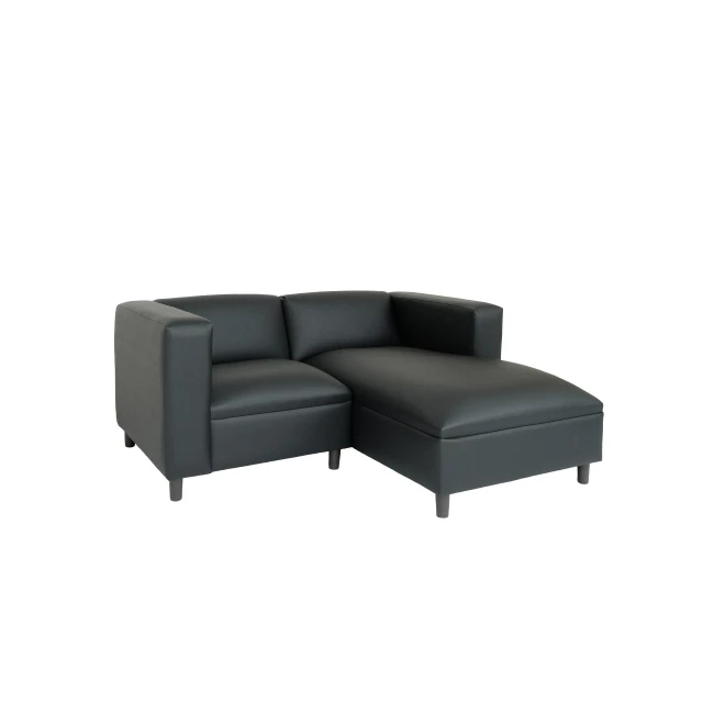 Black faux leather sofa chaise with comfortable armrest and wood accents in a studio setting