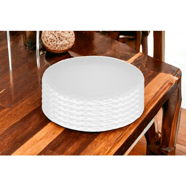 Pebbled porcelain service six dinner plate on wooden table with brown dishware and rectangle tableware