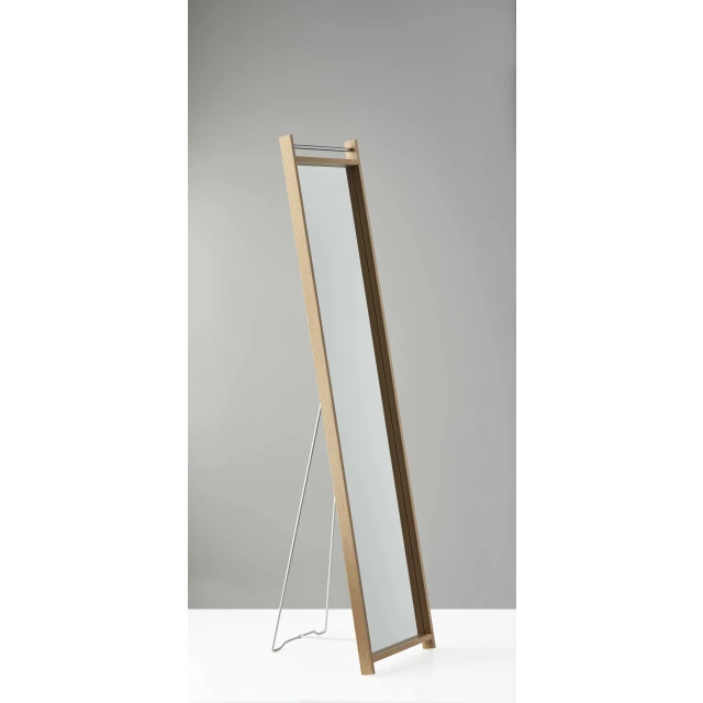 Floor mirror with wooden frame and metal accents in a furniture setting