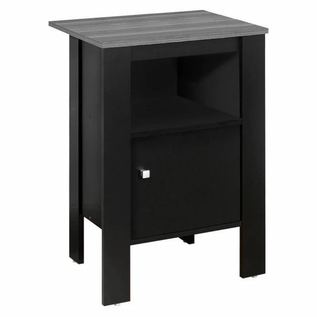 Black nightstand with drawers and wood finish beside a plant