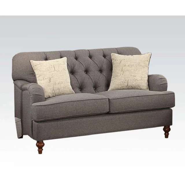 Brown linen curved loveseat with toss pillows in a comfortable studio couch style