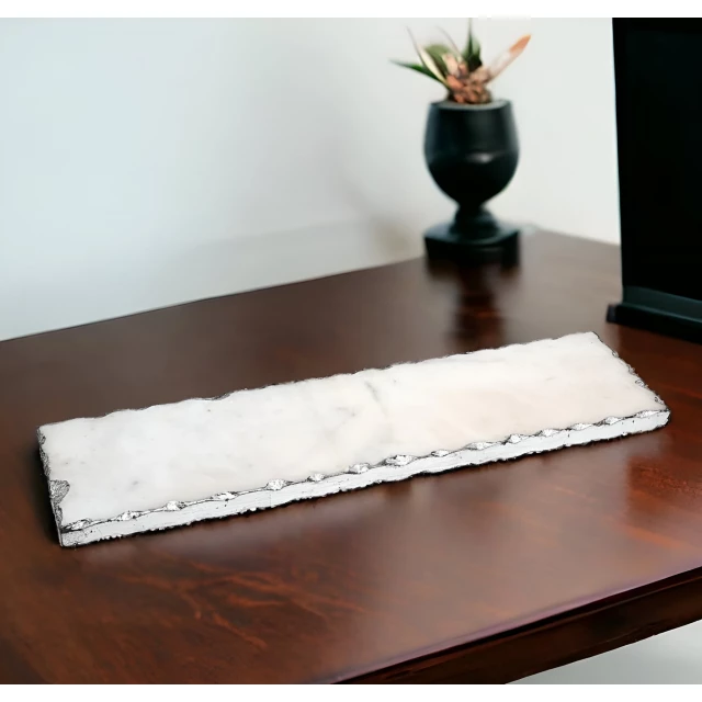 white rectangular marble vanity tray on wooden table with houseplant in background