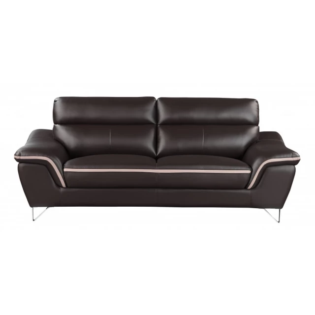 Brown silver leather sofa with comfortable armrests and wooden accents in a studio setting