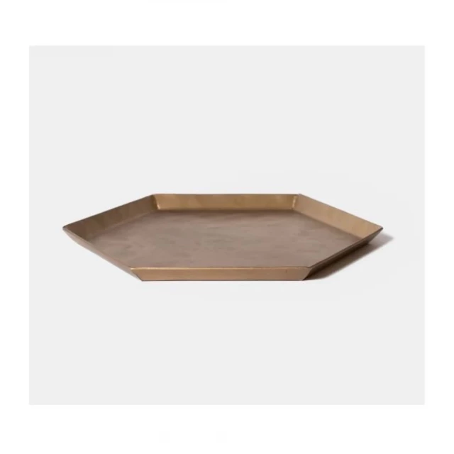 hammered metal hexagonal serving tray on wooden surface