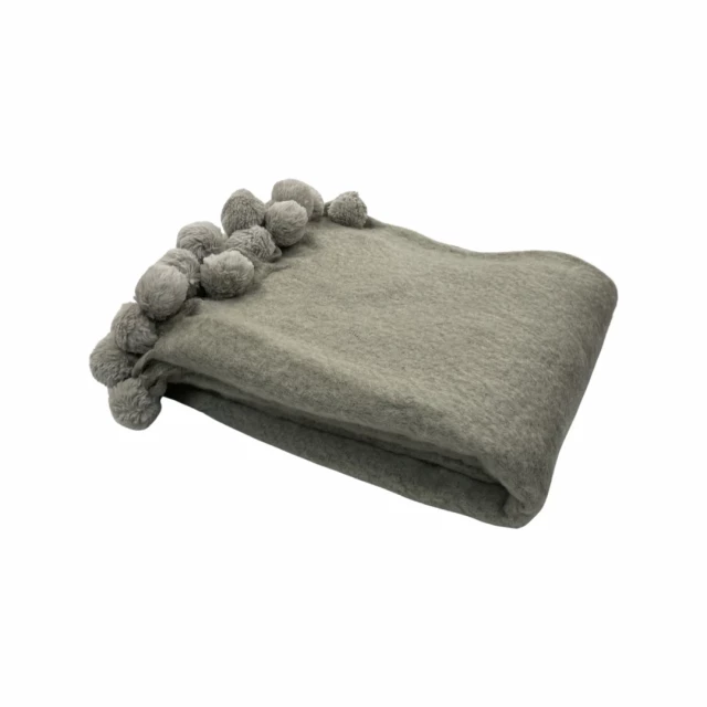 Blend throw pom pom trim detail product image showing a glove with comfortable linens and a wrist gesture