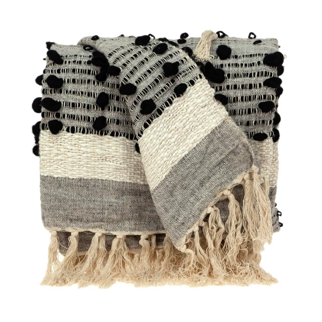 Eclectic gray Percy handloom throw with patterned design on grass
