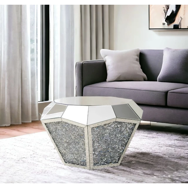 Silver glass round mirrored coffee table in a cozy living room with grey couch and wooden interior design elements