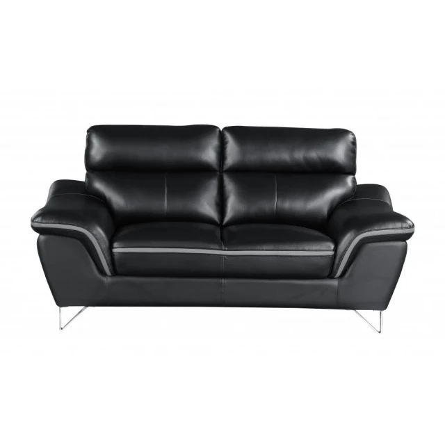 Black silver faux leather love seat with comfortable armrests and wood accents in a studio setting