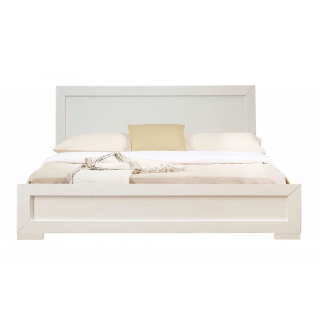 White wood king platform bed in a bedroom setting