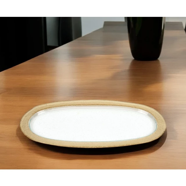 gold oval glass handmade tray on wooden table with dishware and serveware