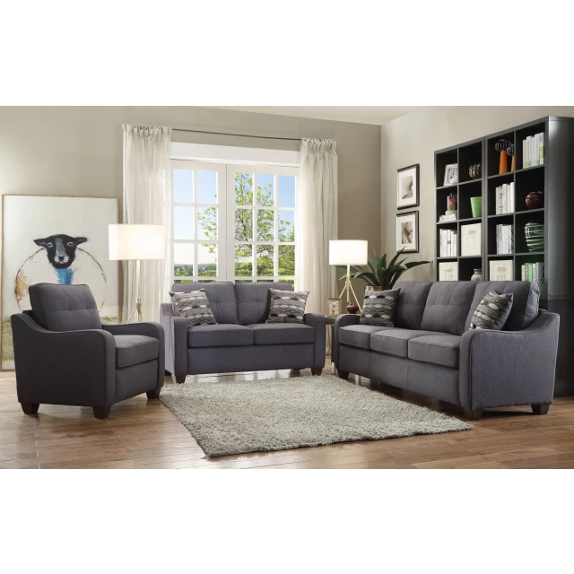 Linen dark brown sofa with toss pillows in a cozy living room setting with wood flooring