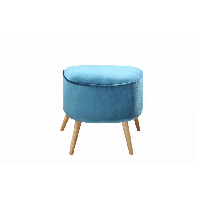 Teal blue velvet ottoman with brown wooden legs in a furniture setting