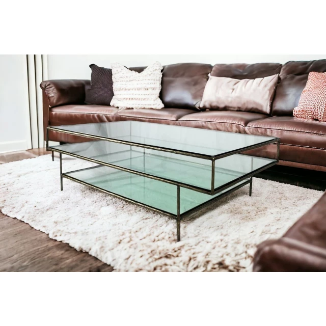 Clear glass triple layered coffee table with wood accents in a modern living room setting