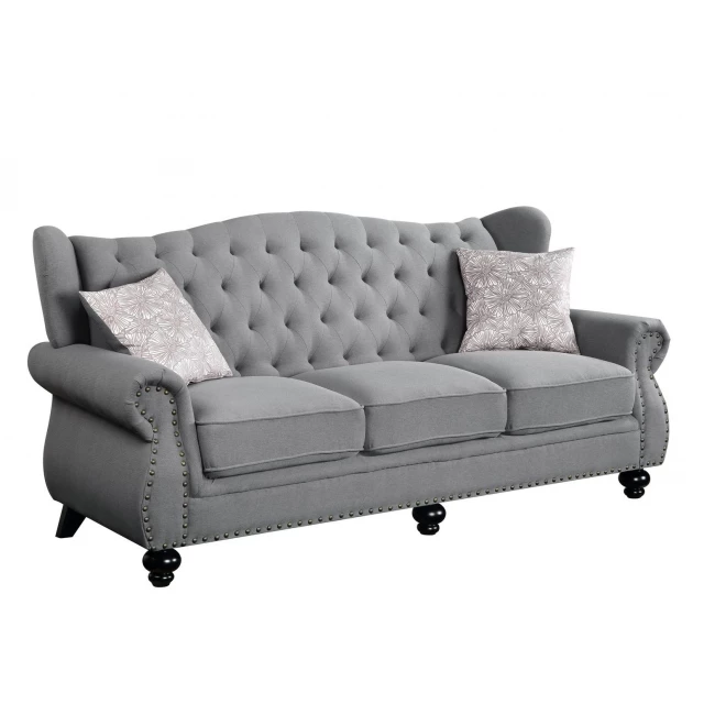 Gray black sofa with toss pillows and beige wood accents in a comfortable studio couch design