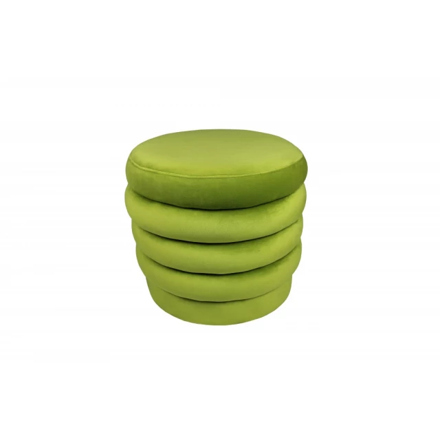 Green velvet tufted round cocktail ottoman in a natural setting with grass