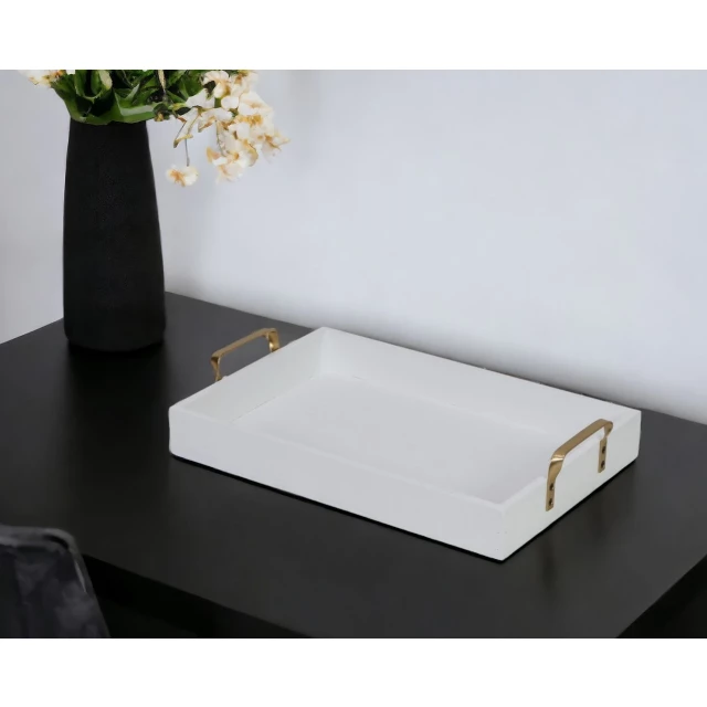 wood handcrafted serving tray with gold handles on wooden table with plant and flowerpot