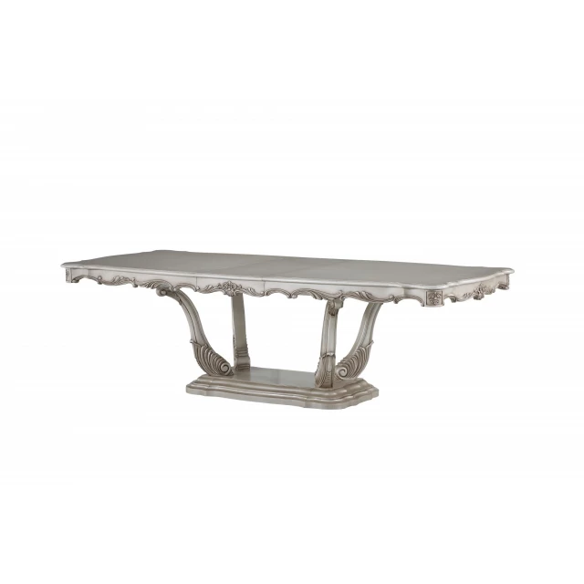 Off white solid wood dining table with pedestal base and rectangular shape in an outdoor setting