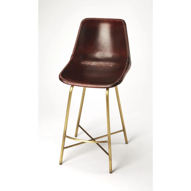 Brown gold leather iron bar chair with wood and metal details on patterned flooring