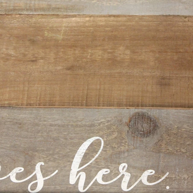 love lives here wood serving tray with brown and beige handwriting on rectangular hardwood