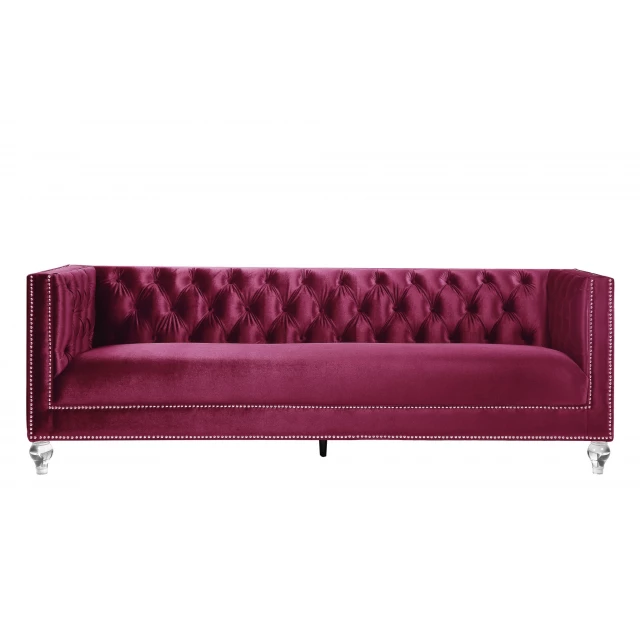 Burgundy black velvet sofa with toss pillows in a comfortable studio couch design