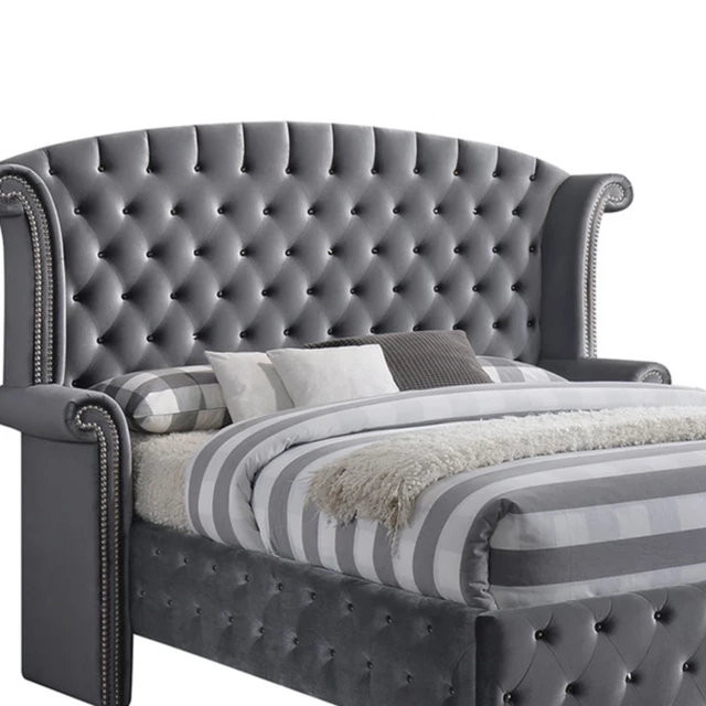 Gray upholstered velvet bed with nailhead trim detail