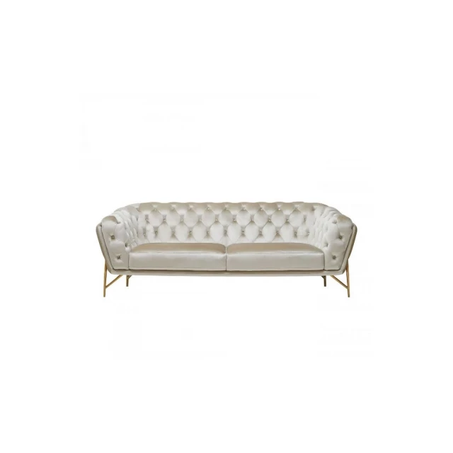 Beige tufted velvet gold chesterfield sofa in a comfortable indoor setting with wooden accents