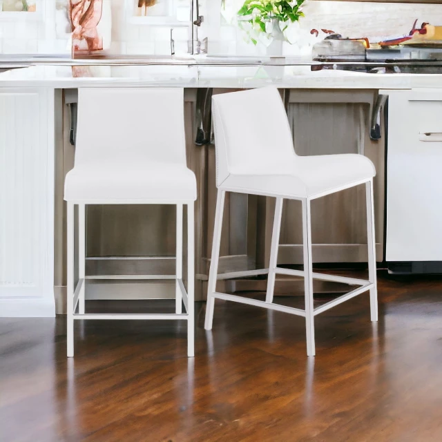 Low back counter height bar chairs in white kitchen with wood flooring