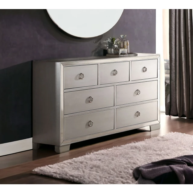 Manufactured wood seven drawer triple dresser in bedroom setting