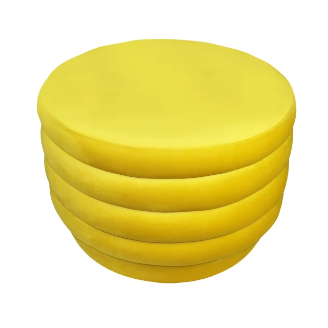 Yellow velvet tufted round cocktail ottoman in a luxurious setting